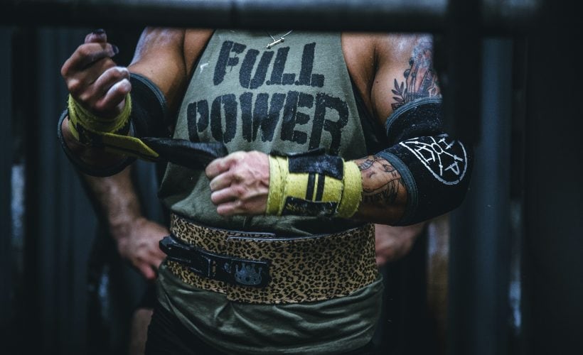 Person wearing athletic gear, including gloves and a tank top that says "FULL POWER."