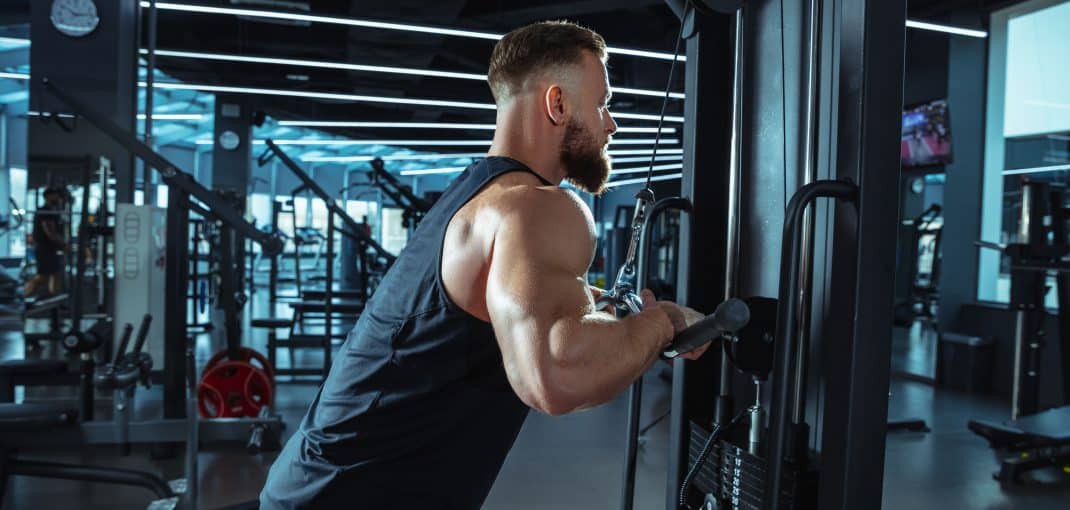 Best choice. Young muscular caucasian athlete training in gym, doing strength exercises, practicing, work on his upper body with weights and barbell. Fitness, wellness, healthy lifestyle concept.