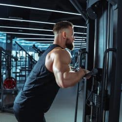 Best choice. Young muscular caucasian athlete training in gym, doing strength exercises, practicing, work on his upper body with weights and barbell. Fitness, wellness, healthy lifestyle concept.