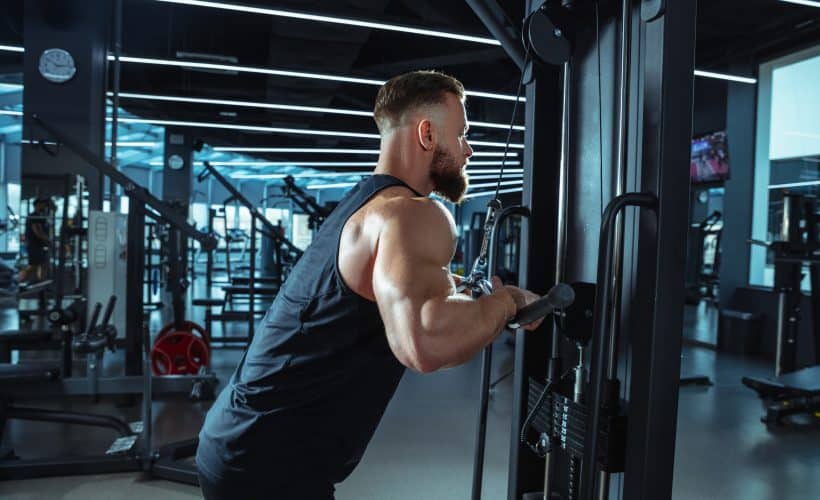 Best choice. Young muscular caucasian athlete training in gym, doing strength exercises, practicing, work on his upper body with weights and barbell. Fitness, wellness, healthy lifestyle concept.