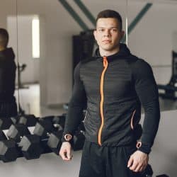 Sports man in the gym. A man performs exercises. Guy with dumbbells.