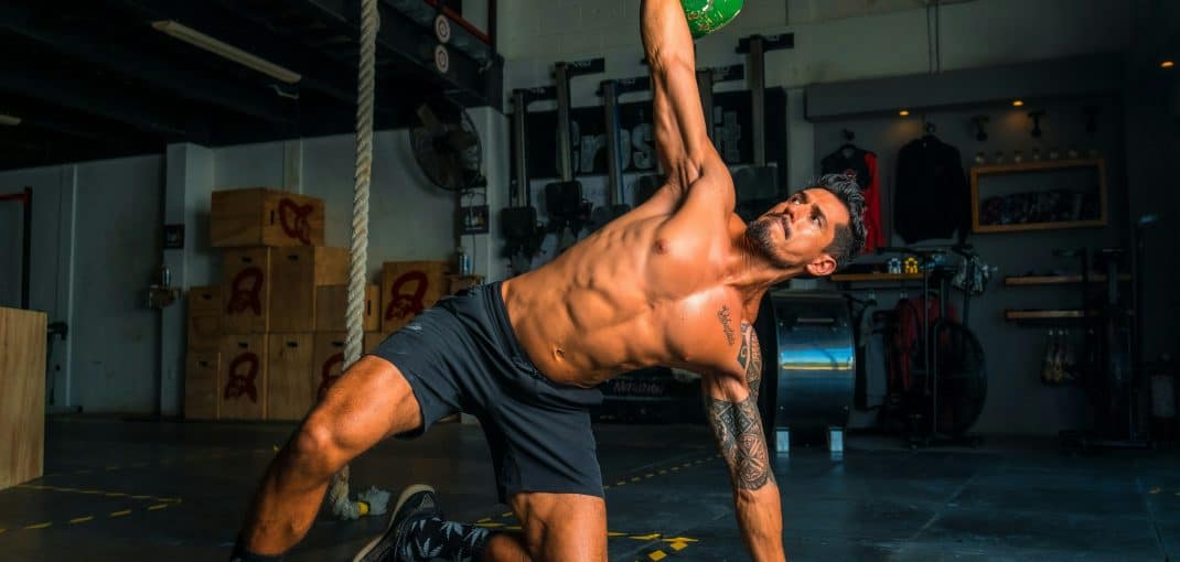 Men lifting kettlebell in black short