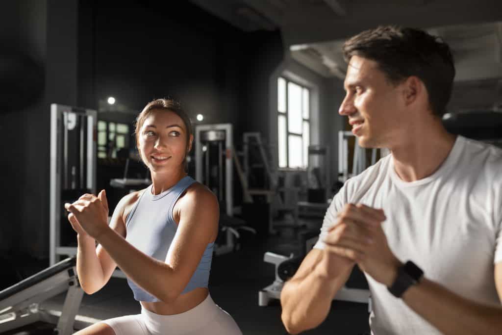 Woman helping man in gym