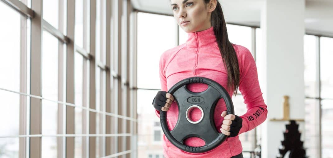 Woman exercising with weight plate