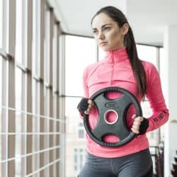 Woman exercising with weight plate