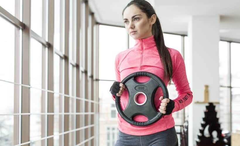 Woman exercising with weight plate