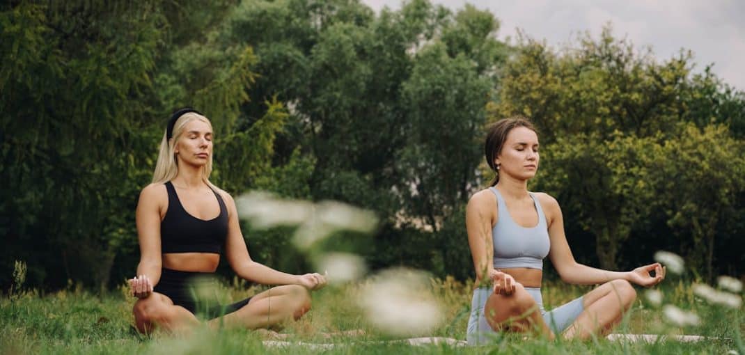 Women meditating in the grass