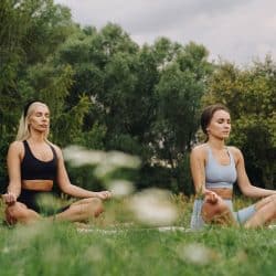 Women meditating in the grass