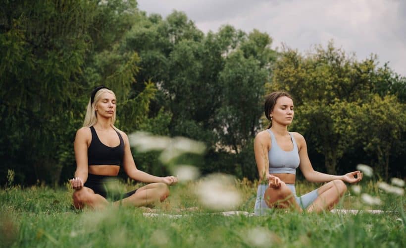 Women meditating in the grass